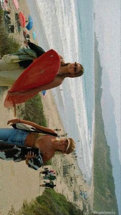 two people standing on the beach with surfboards