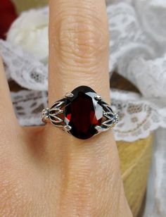 Natural Garnet Ring Tiki Design#122 Custom Made This is a brand new stunning Art Nouveau and Gothic-inspired sterling silver filigree ring. The VS to VVS oval full cut high quality genuine natural garnet is 14mm (9/16th of an inch) by 10mm (3/8 inch) in dimension... The natural 6.5ct to 7ct garnet has a lovely deep red, Merlot color, simply stunning! The inside of the band is marked 925 for sterling. Notice the beautiful filigree swirl like craftsmanship of the silver setting. This is an exquisi Tiki Design, Leaf Filigree, Mystic Fire Topaz, Art Nouveau Ring, Merlot Color, Sterling Silver Garnet Ring, Garnet Ring, Sterling Silver Filigree, Red Band