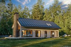 a small house with a metal roof in the woods