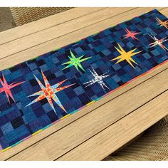 a table runner with stars on it sitting on top of a wooden table next to a wicker chair