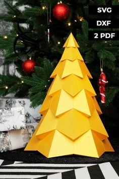 a yellow paper christmas tree sitting on top of a black and white floor