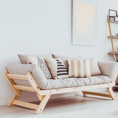 a living room with white walls and wooden furniture on the floor, including a couch