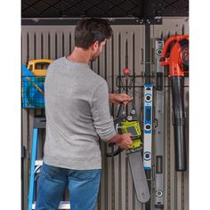 a man is working on a wall mounted tool rack