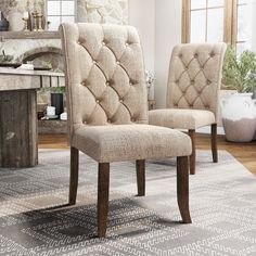 a pair of beige upholstered chairs sitting on top of a carpeted floor