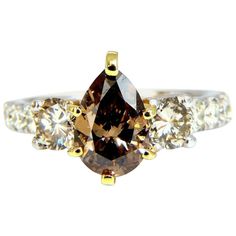 Classic Three & Accent. 1.30ct. Natural Pear diamond ring Fancy brown color Si-1 clarity 7.6 x 6.2mm Very good Cut / Full cut Brilliant Side round white diamonds: 1.00ct Fancy Light Brown color & Si-1 clarity (.50ct each). Additional .50ct Diamonds on shank G-color Vs-2 clarity. 14kt white gold Ring size: 5 (Complimentary resizing vailable) 7.7mm depth. $14000 Appraisal certificate will accompany. Brown Diamond Ring Fine Jewelry, Classic Brown Diamond Jewelry, Luxury Brown Jewelry With Brilliant Cut, Brown Diamond Ring With Diamond Accents For Anniversary, Brown Diamond Ring With Accents For Anniversary, Anniversary Brown Diamond Ring With Accents, Brown Diamond Jewelry For Anniversary, Elegant Brown Diamond Ring, Anniversary Brown Diamond Jewelry