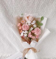 a bouquet of pink and white flowers sitting on top of a table next to a book