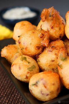 some fried food is on a black plate