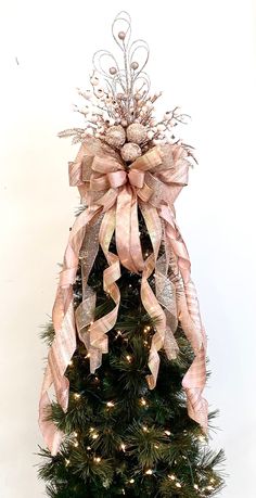 a small christmas tree with pink bows and lights