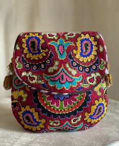 "Medium size Flat Silk Petit Point Handbag created and handmade in Uzbekistan. Lined with silk and cotton ikat fabric, hand woven silk straps and tassels and a magnetic snap closure. Each handbag is hand drawn onto cotton canvas, inspired by original designs from Uzbekistan textile history.  8.5\" high x 8.5\" width, top opening 6\" wide approx. 61\" strap x 1/2\" width.  Can fit largest sizes of iPhone and Android. 100% silk petit point with handwoven silk and cotton ikat lining. The strap is b Artisan Red Embroidered Bag, Handmade Multicolor Tapestry Shoulder Bag, Traditional Woven Multicolor Embroidery Shoulder Bag, Handmade Multicolor Tapestry Bags, Bohemian Embroidered Tapestry Bags, Traditional Handmade Tapestry Bag, Bohemian Multicolor Tapestry Bags, Traditional Embroidered Tapestry Bags, Faux Headboard