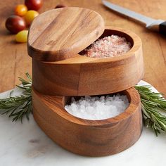 two wooden containers filled with sea salt on top of a table