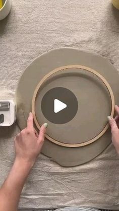 two hands are working on an object that looks like a plate with a video screen