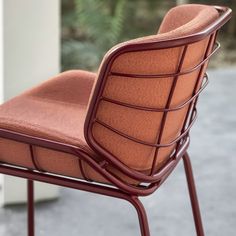 an orange chair sitting on top of a metal frame