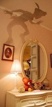 the shadow of a person is projected on the wall above a mirror in a bedroom