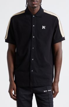 A logo monogram brands the chest of this polo-inspired button-up shirt detailed with track-style stripes at the sleeves. 28 1/2" length ( size Medium) Front button closure Rib collar Short sleeves with rib cuffs 100% cotton Machine wash, dry flat Made in Italy Designer Clothing Black Collared Tops With Contrast Stripes, Black Shirt With Striped Collar, Collared Cotton Shirt With Signature Stripes, Classic Collared Shirt With Signature Stripes, Shirt Detail, Track Shorts, Palm Angels, Monogram Logo, A Logo