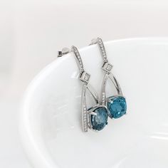 These beautiful drop earrings feature a pair of 11.55 carat weight cushion cut Blue Zircon gemstones with natural earth mined diamonds set in solid 14K gold. These earrings make a lovely December birthstone gift for your loved ones! These earrings are made with solid 14k Gold and natural earth mined SI / G-H Diamonds. As listed, these earrings are ready to ship. If you're interested in purchasing this setting with a different center stone please message us! Cushion Cut Gemstone Earrings For Formal Occasions, Elegant Cushion Cut Gemstone Earrings, Cushion Cut Gemstone Earrings In Fine Jewelry Style, Fine Jewelry Cushion Cut Gemstone Earrings, Cushion Cut Gemstone Earrings Fine Jewelry, Cushion Cut Gemstone Earrings For Fine Jewelry, Elegant Blue Topaz Cushion Cut Jewelry, Elegant Cushion Cut Jewelry With Gemstone Accents, Elegant Blue Topaz Earrings With Prong Setting