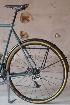 a blue bicycle parked in front of a brick wall