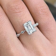 a woman's hand with an engagement ring on it and a diamond in the middle