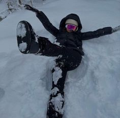 a person laying in the snow on their back