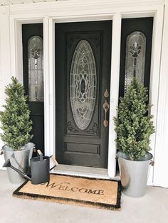 two potted plants are sitting on the front step of a door mat that says welcome