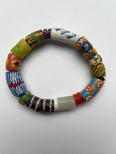 This colorful bracelet is handmade from recycled glass, formed into beads known as Krobo beads, hand painted, and fired in a kiln in Ghana, West Africa.  The bracelet is 7 1/2" and is strung on 2mm black elastic cord. It features hand-painted African designed glass beads. Other sizes may be ordered as well as earrings and other jewelry. Just contact us.  All proceeds from the sale of this jewelry go to our non-profit organization Mawuvio's Outreach Programme, which is providing free education an Multicolor Round Beaded Wristband, Multicolor Wristband With Large Round Beads, Adjustable Recycled Glass Beads With Large Beads, Artistic Adjustable Beaded Bracelets, Artisan Multicolor Beaded Stretch Bracelet, Traditional Hand Painted Adjustable Bracelets, Artisan Multicolor Round Beads Stretch Bracelet, Artisan Multicolor Stretch Bracelet With Round Beads, Artistic Handmade Multicolor Beaded Bracelets