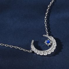 The crescent moon symbolises new beginnings and the ever-changing cycles of life. Crafted in sterling silver, this necklace features a delicate crescent moon and a twinkling blue star. This piece embodies the celestial beauty and the mystical allure of the night sky. Wearing this necklace is like carrying a piece of the night sky close to your heart. It serves as a reminder of the beauty and vastness of the universe, igniting a sense of wonder and inspiration within you.Carat Weight: 0.659 ctSto Elegant Star-shaped Sun And Moon Necklace, Elegant Sterling Silver Half Moon Necklace, Sterling Silver Crescent Clavicle Necklace, Sterling Silver Crescent Clavicle Chain Necklace, Celestial Sterling Silver Crescent Necklace, Sterling Silver Crescent Celestial Necklace, Celestial Crescent Sterling Silver Necklace, Celestial Moon Shaped Sterling Silver Necklace, Sterling Silver Moon Necklace In Celestial Style