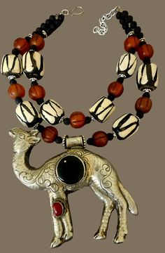 This rare and scarce tribal statement necklace is new and unworn from my private collection. It features a very hard to find Tibetan Repousse Camel pendant with inlaid black onyx and red carnelian. I remain uncertain about the small gold metal spor at the 11 o'clock position in the onyx, but I purchased the stone like this. The camel is as ornate on the back as it is on the front, and measures a lightweight 5.25" x 5" (the camel is hollow). The adjustable double strand beaded necklace ranges fro Artisan Black Ceremonial Jewelry, Black Bohemian Necklace For Ceremonial Occasion, Traditional Black Necklaces With Large Pendant, Traditional Black Necklace With Large Pendant, Artisan Black Jewelry For Festivals, Jewellery Shop Design, Turquoise Western, Red Carnelian, Chest Piece