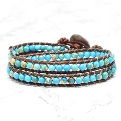 Genuine leather and turquoise Jasper stones make up this classic boho style, double wrap bracelet. Always a favorite for it's versatility and simplicity ~ and when you think bohemian, you think turquoise! Turquoise looks gorgeous on every skin tone. Give it a try and enjoy the versitility. 4mm (.157") diameter turquoise Jasper gemstones Greek cast silver finished button, about 16mm (5/8") in diameter Rust brown leather Signature Bluefish logo heart charm 34 - 39 cm/13.5 - 15.5" length 2 button l Classic Boho Style, Gemstone Wrap Bracelet, Turquoise Wrap Bracelet, Beaded Leather Wraps, Double Wrap Bracelet, Beaded Wrap Bracelets, Beaded Wraps, Bracelet Beaded, Bead Leather