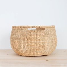 a woven basket sitting on top of a wooden table