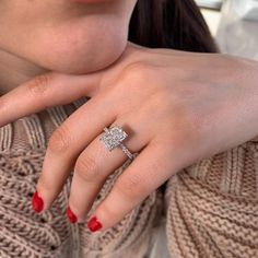 a woman wearing a diamond ring on her finger