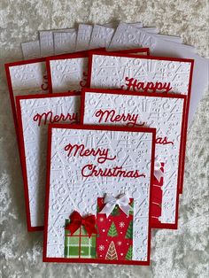 four christmas cards with red and white envelopes