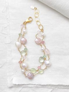 This luxe layered bracelet boasts a lavish combination of pink and green gemstones and freshwater pearls, creating a refined and feminine design. Lobster clasp and extender chain allow for an adjustable fit. Bracelet length:  7.5-8.5 inches Materials:  gold fill, rose quartz, prehnite, tourmaline, mystic moonstone, green amethyst, cultured freshwater pearls GIFTING ~ Jewelry gift box included. ~ I am happy to ship directly to the recipient.  Enter their address during checkout. ~ If you would like a gift note included in the package, please leave the text of the note in the "Add a note to Marsh Creek Jewelry" message box at checkout. FREE SHIPPING ~ Orders ship within 2 business days. ~ Free shipping is First Class ~ Priority Mail and Express Shipping upgrades are available during checkout Elegant Double Strand Bracelets With Gemstone Beads, Elegant Double Strand Gemstone Beads Bracelets, Elegant Double Strand Natural Stones Bracelets, Elegant Multi-strand Gemstone Beaded Bracelets, Elegant Pearl Beaded Bracelets With Gemstones, Elegant Pink Bracelets With Natural Stones, Elegant Double Strand Beaded Bracelets With Faceted Beads, Elegant Double Strand Bracelet With Faceted Beads, Elegant Double Strand Faceted Beaded Bracelets