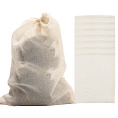 a white bag and some pieces of paper sitting next to each other on a white surface