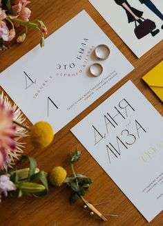 the wedding stationery is laid out on top of the table with flowers and rings