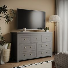 a flat screen tv sitting on top of a dresser in a living room next to a window