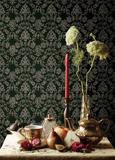 a table topped with vases filled with flowers next to a candle and other items