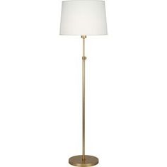 a floor lamp with a white shade on the base and a gold metal stand light