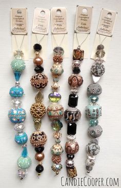 there are many different types of bead charms on the table with tags attached to them