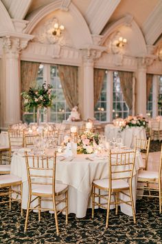 the tables are set with white linens and gold chairs for an elegant wedding reception