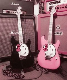 two guitars with hello kitty on them are sitting next to each other in the room