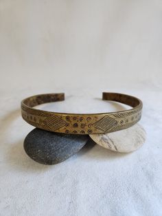 Offered for sale is a beautiful vintage embossed African Bronze choker necklaces.  This wonderful necklace is beautifully embellished with a wonderful soft glow/patina that only comes with age.  The necklace is in wonderful condition.  The necklace measures approximately 7 inches in diameter and .75 inches wide.  It is very sturdy heavy weighing approximately one pound. 2 Etched Brass Bracelet Jewelry, Etched Brass Bracelet, Vintage Gold Bracelets With Oxidized Finish, Vintage Handmade Brass Choker, Handmade Vintage Brass Choker, Vintage Ceremonial Choker Necklace, Bohemian Patina Necklaces Collectible, Bronze Bohemian Jewelry With Patina, Bohemian Bronze Jewelry With Patina