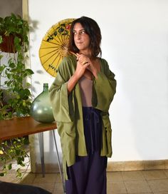 Handmade green women's boho kimono robe cardigan jacket with pockets. Our kimono robe comes in a wide and loose style for an oversize fit, one-size-fits all. Made in an earthy green viscose cotton mix fabric that has a slight silky shine in light, that is super light, floaty and easy to wear. Finished with wide quarter length sleeves and large oversize pockets on each side. We have also added a slightly longer back panel for a more flattering fit. Pictured is our knee length version, but this ki Green Oversized Kimono For Spring, Oversized Green Kimono For Spring, Oversized Green Spring Kimono, Green Open Front Summer Outerwear, Green Open Front Outerwear For Summer, Green Kimono For Spring Loungewear, Green Spring Kimono For Loungewear, Green Bohemian Robe With Kimono Sleeves, Green Spring Loungewear Kimono