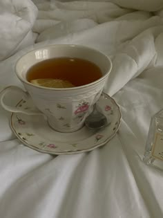 a tea cup and saucer on a bed