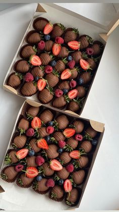 two boxes filled with chocolate covered strawberries on top of each other, next to one another