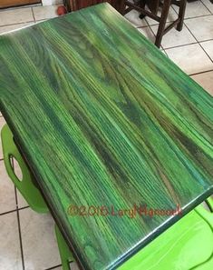 a green table sitting on top of a tiled floor