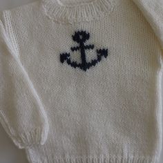 "Fitting approximately ages 2 to 2.5 years, this little hand-knit white toddler sweater with a navy anchor motif is sure to be a hit with your little sailor. This white pullover sweater is knit with a soft yarn. I used easy care, light weight acrylic yarn; it is machine washable and machine dryable, or lay flat to dry. Measurements are below: Age 2 - 2.5 years (approximate) Actual chest measurement of garment = 23\" Sleeve length from underarm = 10 1/2\" Back length from base of neck = 12 1/2\" Sailor Sweater, White Pullover Sweater, Navy Anchor, Navy Sailor, White Pullover, Toddler Sweater, Handmade Knit, Handmade Knitting, Soft Yarn