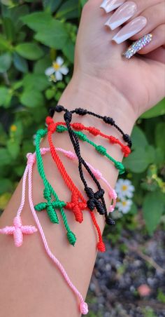 a woman's arm with different colored bracelets on it