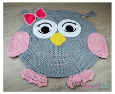 a crocheted owl rug is on the floor with pink and gray yarns