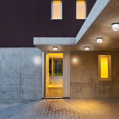 an entrance to a building with three lights on the outside and one light on the inside