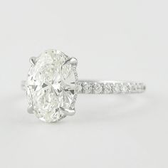 an oval cut diamond ring with pave set shoulders