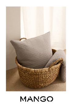 a basket with two pillows in it and the words mango written on top of it